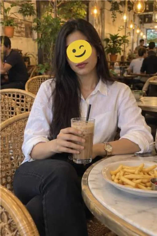 Aadhya, 24, call girl in Kurla, Mumbai: at a cafe in a white shirt with a cold coffee, an emoji over her eyes