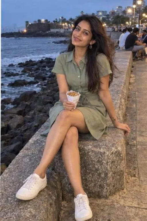 Riya, 24, call girl in Bandra, Mumbai: sitting on the Bandstand sea wall at dusk in an olive shirt dress